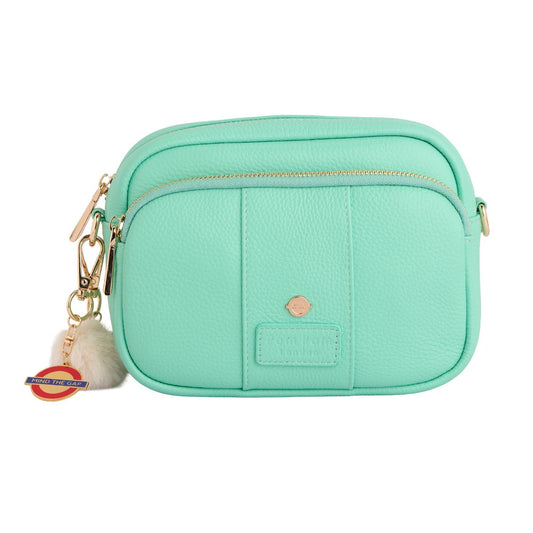 Mint green crossbody bag with a keychain on a white background